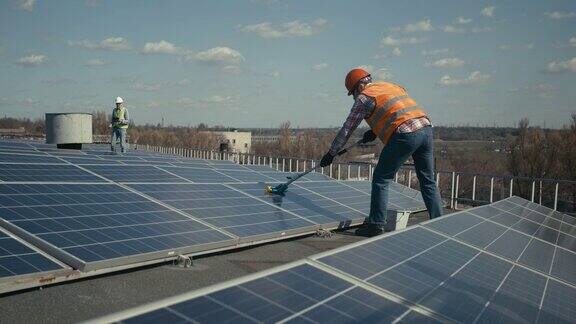 技术人员正在清洁平屋顶上的太阳能电池板