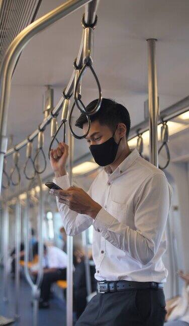 亚洲商人在地铁上戴着防护口罩