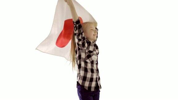 可爱的女孩有趣的舞蹈与日本国旗在白色的背景