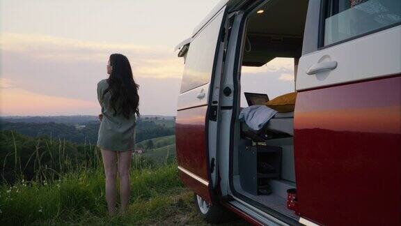 戴斯:黄昏时分年轻女子在乡间欣赏风景呼吸新鲜空气