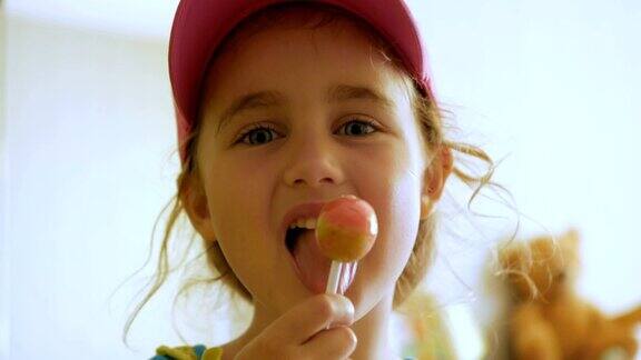 小女孩一边盯着镜头一边享受棒棒糖孩子吃糖果糖果糖