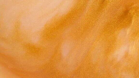 彩色的金色沙子在彩色的液体中有机地移动