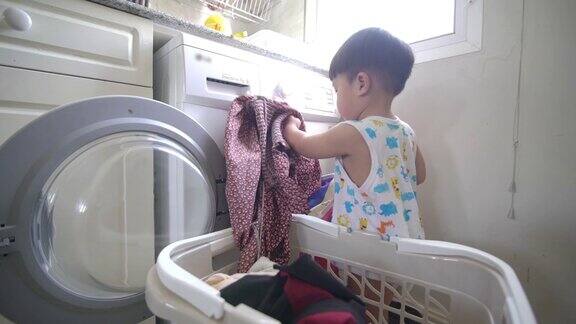 亚洲男婴装衣服在家里的自动洗衣机洗衣服