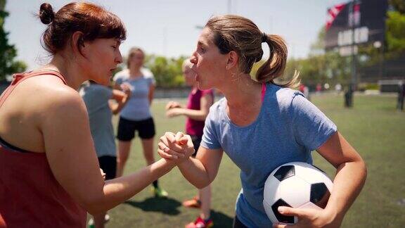 女足球运动员在比赛开始前交谈和握手