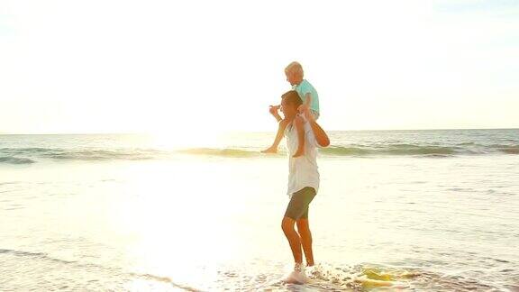 日落时分父亲背着儿子在海滩上散步