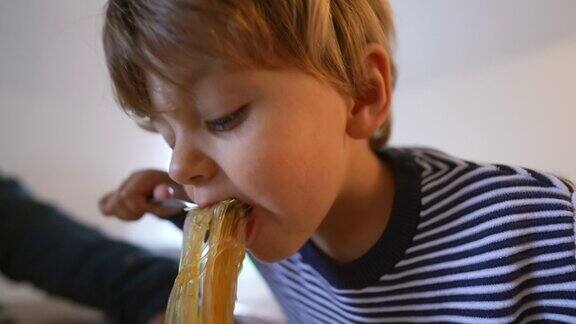 小孩吃亚洲面条小孩用叉子吃意大利面