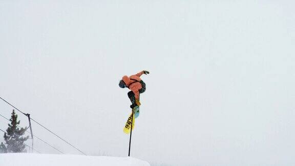完整的冬季装备滑雪板完成一个“前侧360尾巴抓取”在博尔德附近的埃尔多拉滑雪度假村跳跃的技巧科罗拉多州在一个下雪的阴天