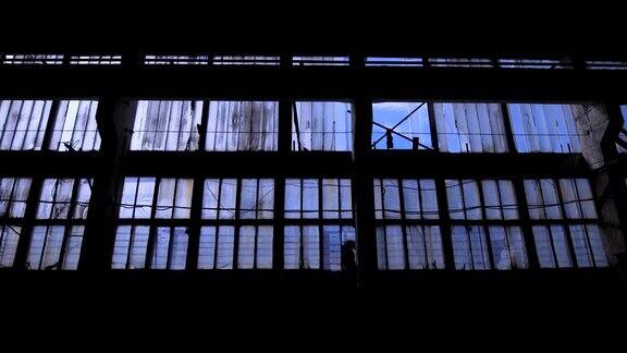 透过破旧的工业建筑的窗户看到蓝天