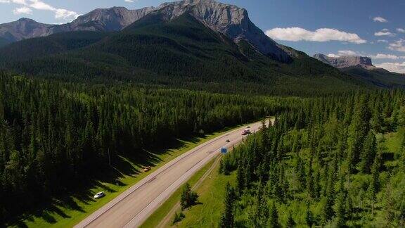 无人机俯瞰森林和山脉之间的高速公路