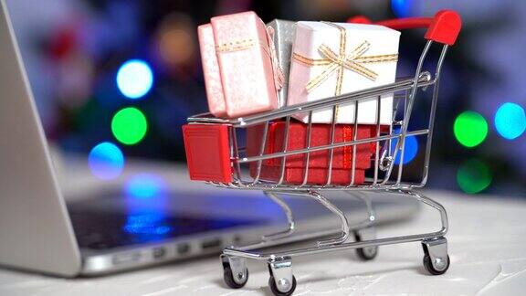 圣诞节的网上购物女人买礼物准备圣诞节购物车和礼物盒之间圣诞快乐寒假销售理念有选择性的重点