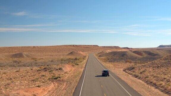 空中镜头:一辆黑色SUV在沙漠中行驶
