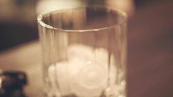 赶时髦的人喝将可乐倒入加冰的玻璃杯中威士忌酒杯冰饮料