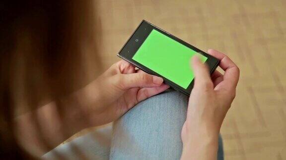 漂亮女人拿着绿色屏幕的智能手机还能滚动屏幕
