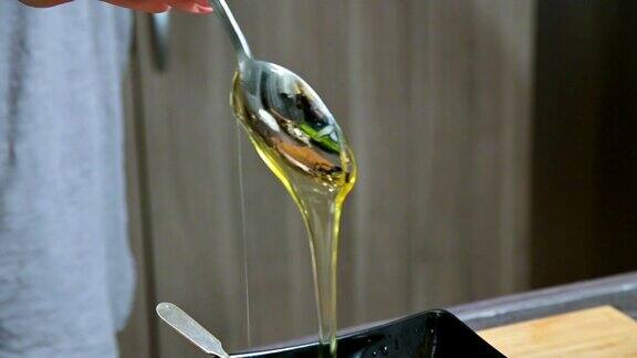 女人的手在一个家庭厨房的特写把一勺蜂蜜到碗里准备酱汁