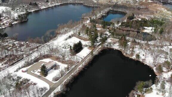 新泽西州伦道夫郊区丘陵湖泊下雪的航拍视频