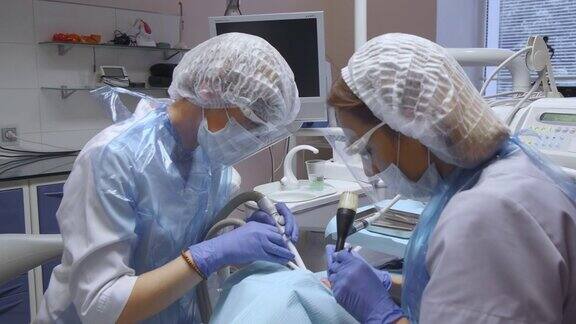 两个女牙医在病人的牙齿上做手术的特写现代牙科医疗设备