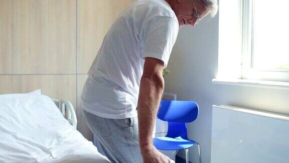 一位拄着拐杖在医院里行走的老年残疾人