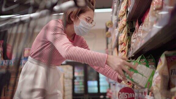 年轻女子戴着防护口罩在超市购物
