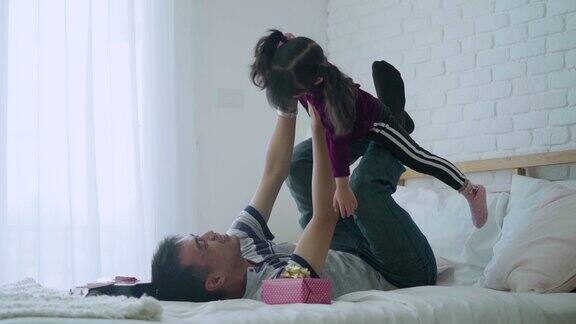 女儿和父亲一起在床上玩幸福的家庭