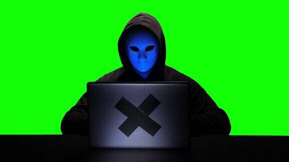 暗网黑客在他的笔记本电脑上输入代码色度键绿色屏幕背景
