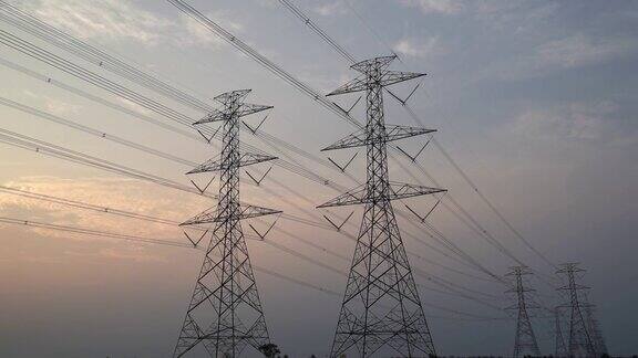 日落时分高压电塔、塔架和高压电力线的时间流逝