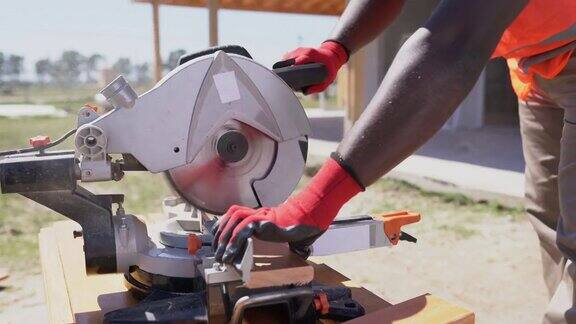 非裔美国工人在建造木结构房屋时锯木板的细节