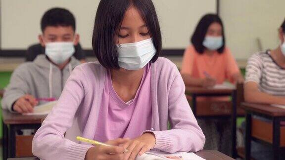 亚洲小学生戴上口罩预防病毒上课开始重开