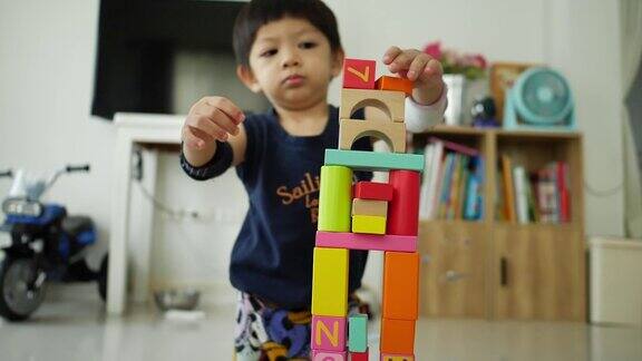慢镜头快乐的男孩玩玩具积木