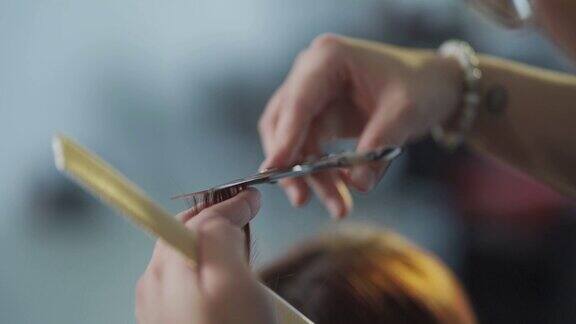 慢镜头亚洲华人发型师在美发沙龙为她的顾客理发