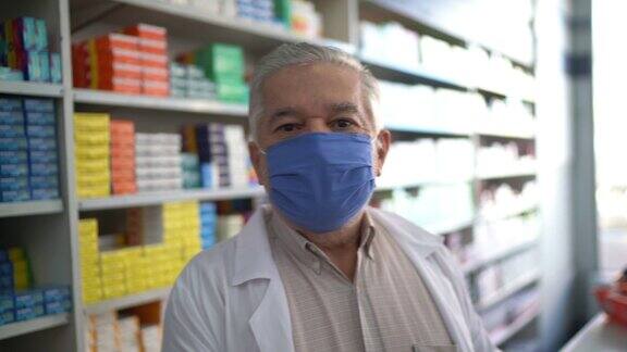 男性年长药剂师戴着口罩在药房的肖像