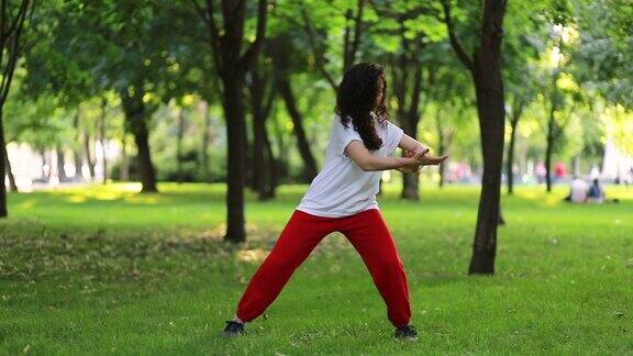 一个女人在公园里练太极气功东方武术