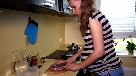 孕妇在砧板上用刀切鲜肉