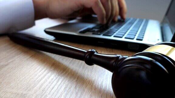 在法庭上用键盘打字的男人桌上放着小木槌和笔记本电脑