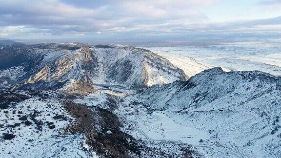 多云天空下雪山景观鸟瞰图冬天的无人机视频高质量4k镜头