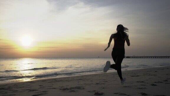 运动女子慢跑在沙滩上跑步