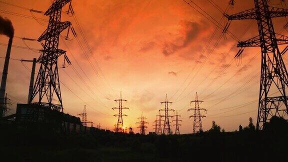 红色的日出和电线水电输电线塔构成电网日落时的电力塔全景运动镜头