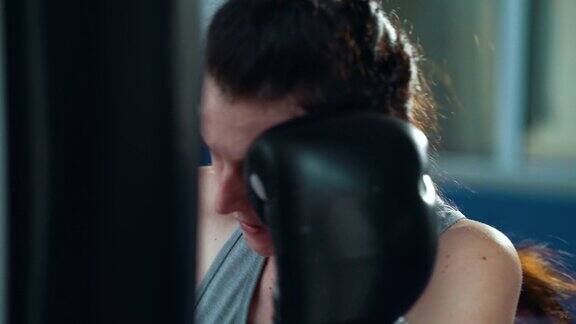 女拳击手在健身房用拳击袋锻炼