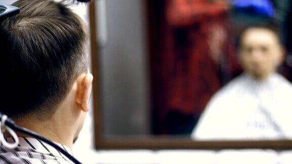 特写从后面看在一个理发店一个男人的发廊一个男人的头发剪和造型