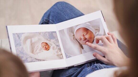 前视图母亲和女儿观看新生婴儿出院时的相册