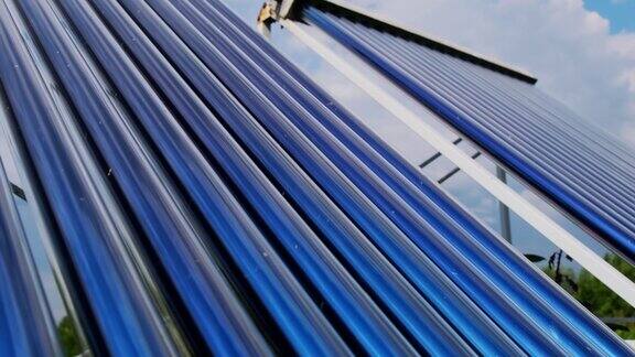 真空收集器是房子附近的太阳能水加热系统高层建筑屋顶上的太阳能热水器单元锅炉蓝天背景与云彩太阳能热水系统