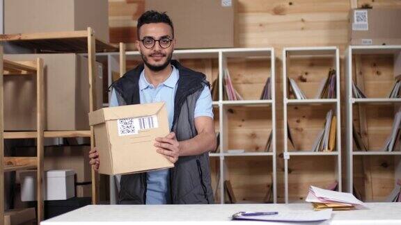 微笑的中东邮政工人赠送包裹