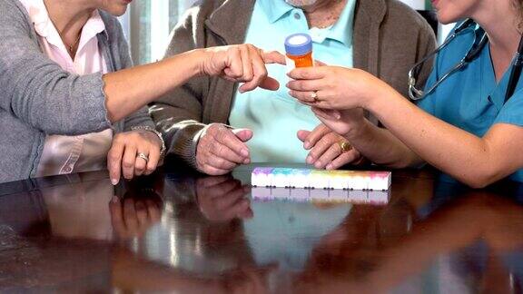 西班牙护士向一对老年夫妇解释药物