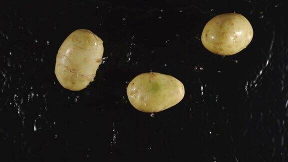 俯视图:土豆落入水中溅起水花-慢镜头