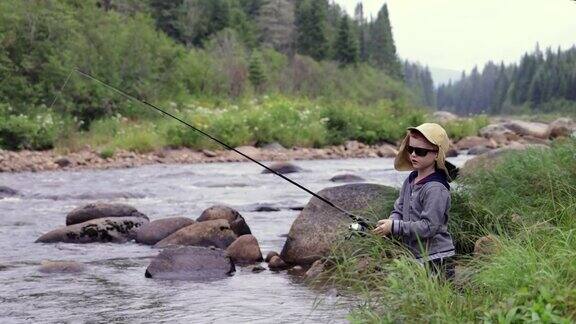 可爱的红发男孩在魁北克的河里钓鱼