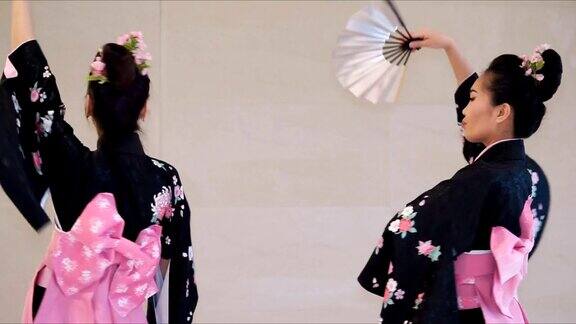 两个艺妓穿着传统的日本和服和扇子