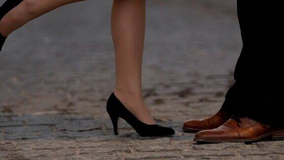 穿着高跟鞋的女人接近并亲吻男友在户外双腿特写