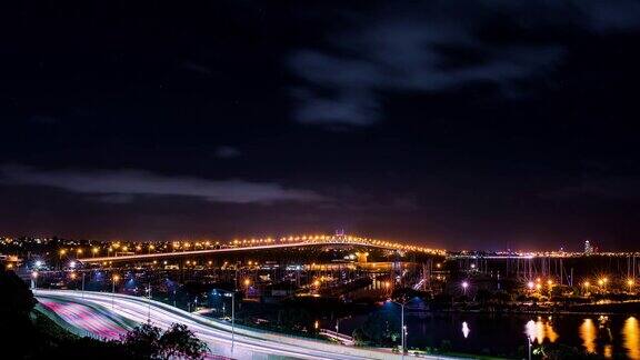 延时摄影在海上亮着灯的桥和高速公路上行驶的汽车