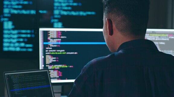 年轻的亚洲人开发程序员软件工程师IT支持晚上加班在电脑上检查漏洞系统中的代码