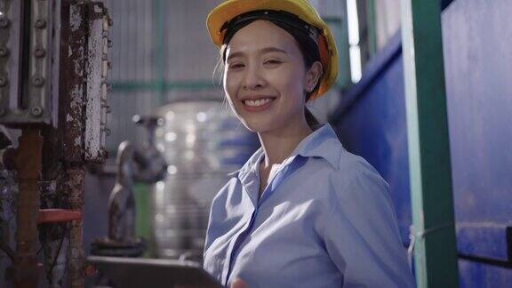 工厂里微笑的年轻女操作员
