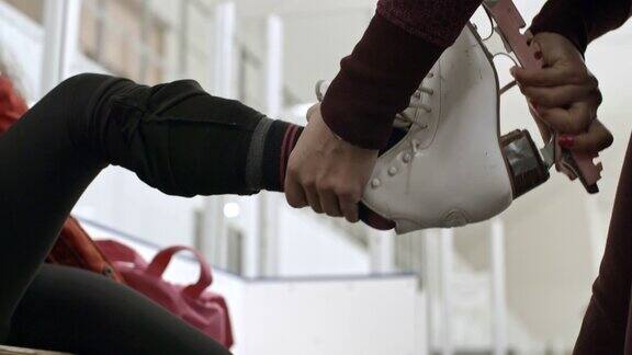 教练帮助女孩穿上溜冰鞋